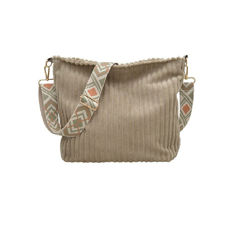 Beige handbag with patterned strap on a white background