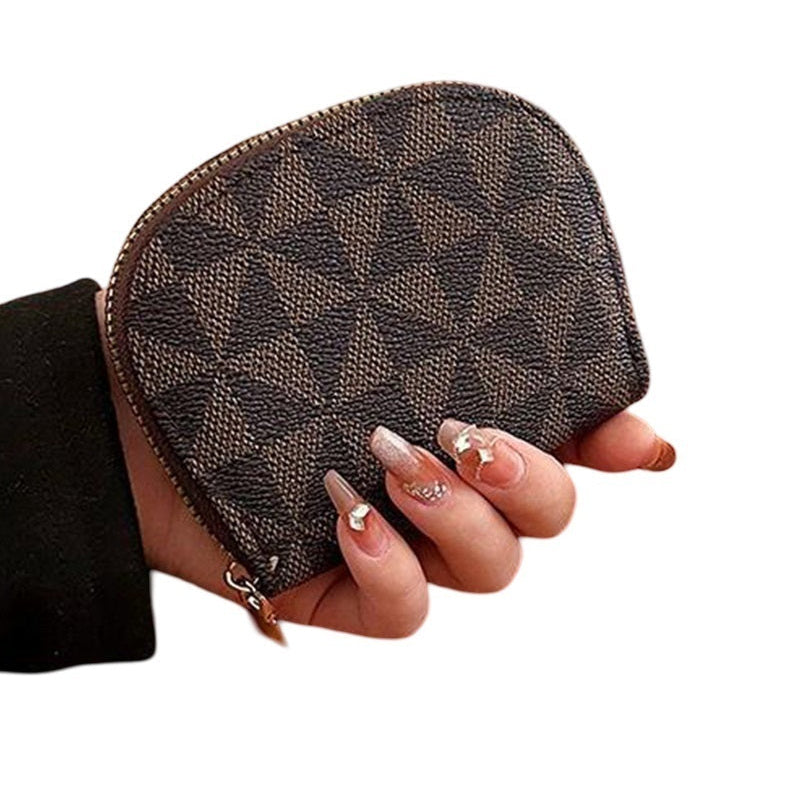 Brown patterned pouch held by a hand on a white background