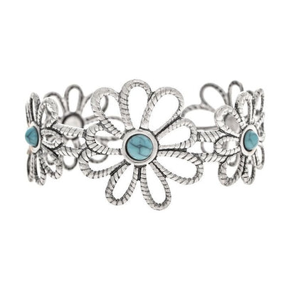 A silver-toned Southwestern-style cuff bracelet featuring a central daisy flower motif with three smaller matching flowers on each side, accented by round light blue turquoise stones.