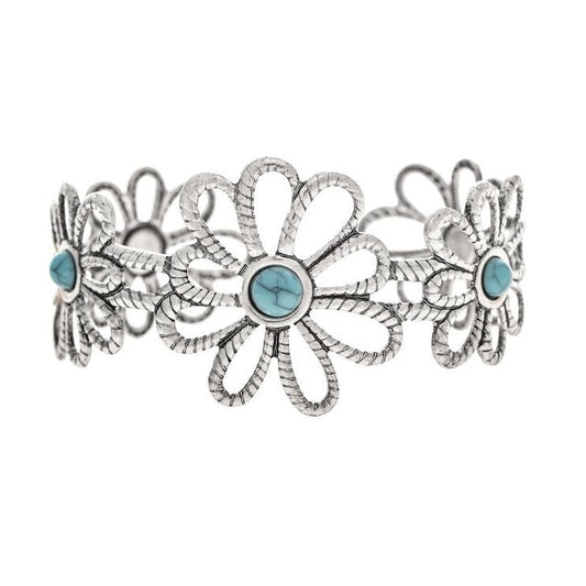 A silver-toned Southwestern-style cuff bracelet featuring a central daisy flower motif with three smaller matching flowers on each side, accented by round light blue turquoise stones.