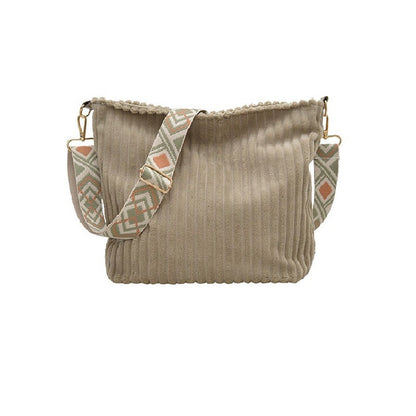 Beige handbag with patterned strap on a white background