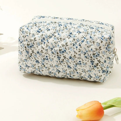 Floral-patterned toiletry bag on a white background with a tulip.