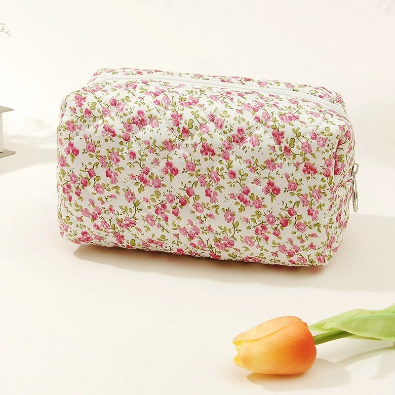 Floral-patterned cosmetic bag on a white background with a tulip.