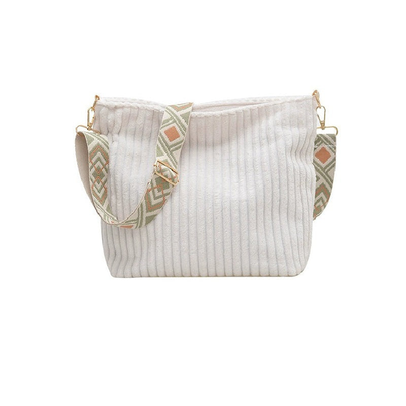 White ribbed handbag with decorative straps on a white background
